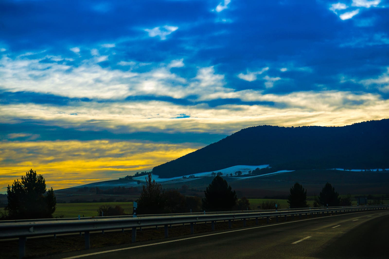 A highway running toward the hills at golden hour.
